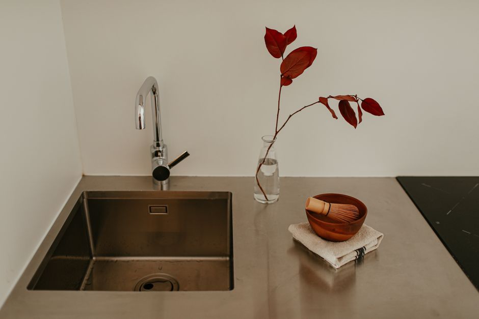 Strakke witte keuken met Zen-invloed en planten.